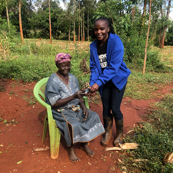 Junge Frau überreicht älterer Frau eine Solarlampe in Projekt von Solafrica